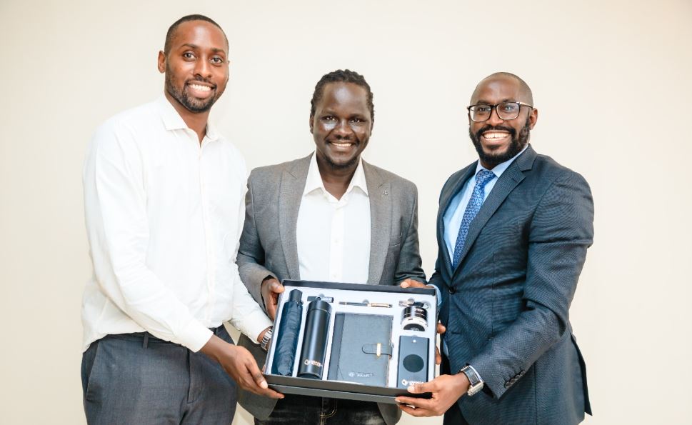 R-L: Uganda Baati’s Ian Rumanyika hands over a gift of appreciation to President of the E-Trade and Startup Association of Uganda, Ricky Rapa Thompson and Chairperson Board, Ron Kawamara.
